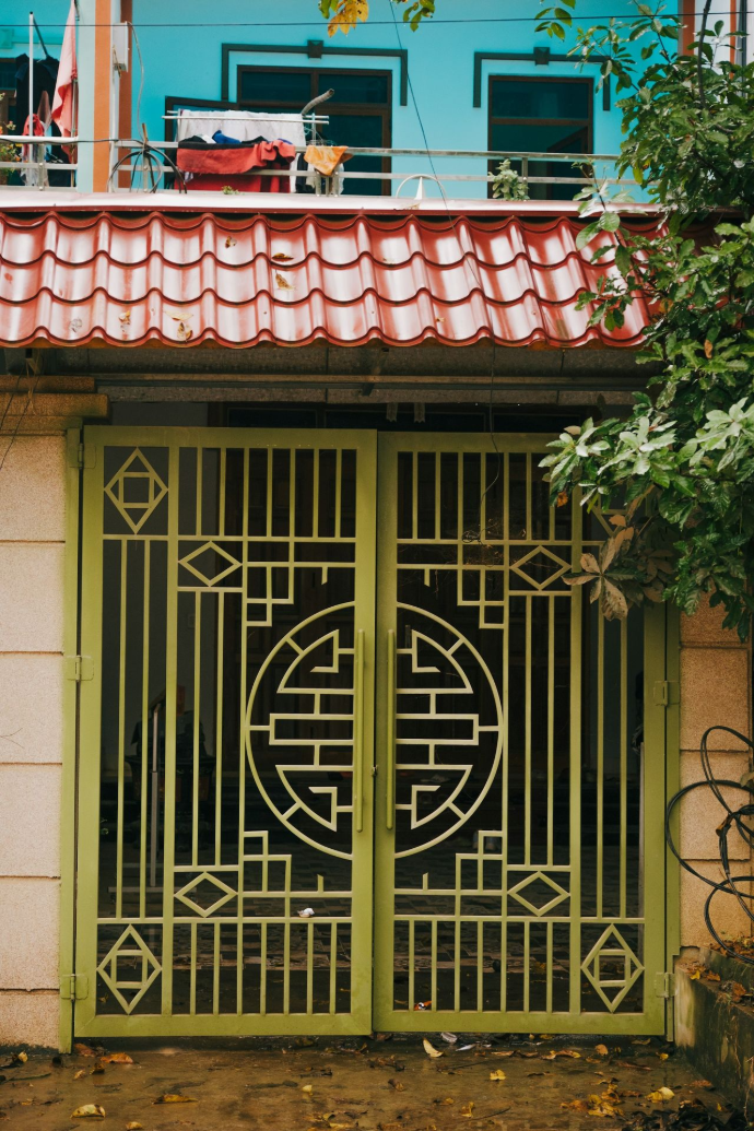 a green gate with a red roof in front of a building