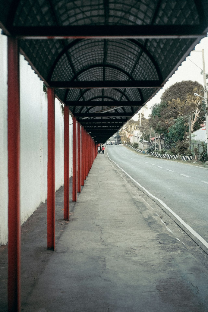 a row of red poles next to a street